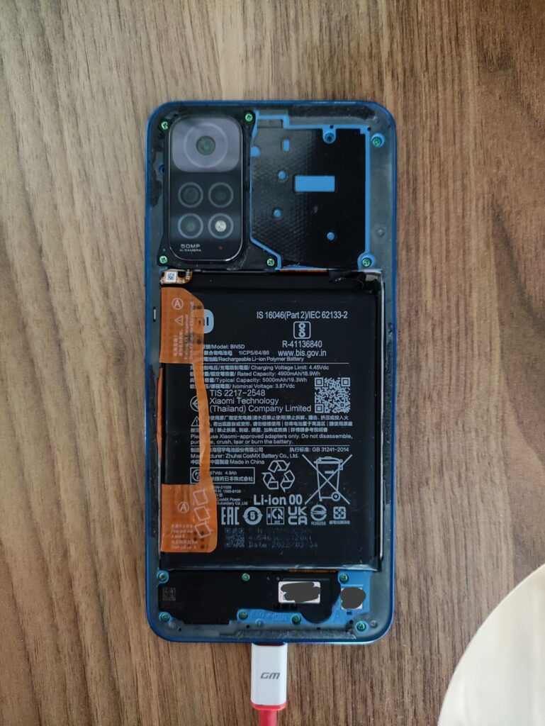 Arka kapağı açılmış, ekranı sökülmüş ve USB'ye bağlı Redmi Note 11